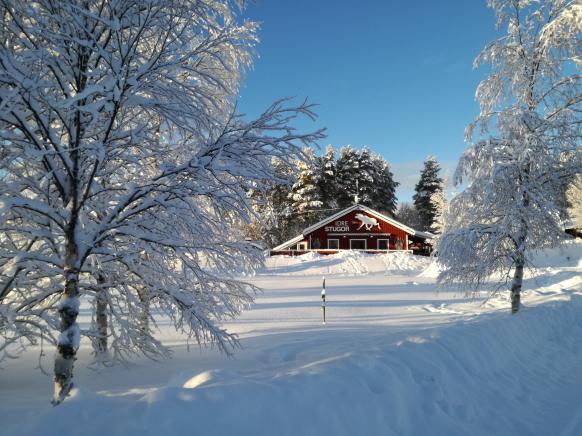 Haupthaus der Hüttenalga Idre Stugor, schneebedeckt bei Sonnenschein