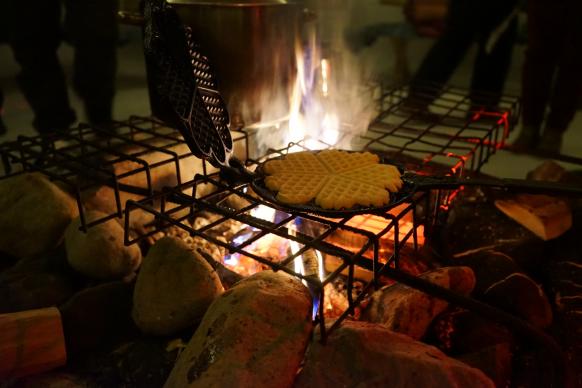 Waffel in gusseisernem Waffeleisen über offenem Feuer gebacken