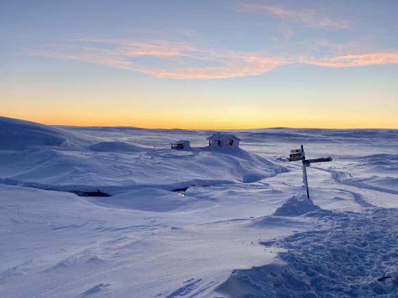 Hütte in Winterlandschaft nach Sonnenuntergang