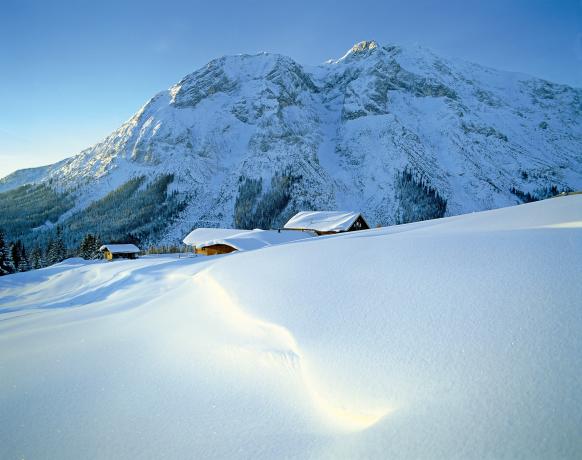 Schneebedeckte Winterlandschaft Österreich mit Berghütten
